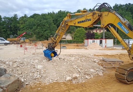 Le godet concasseur ramasse les pierres à concasser.